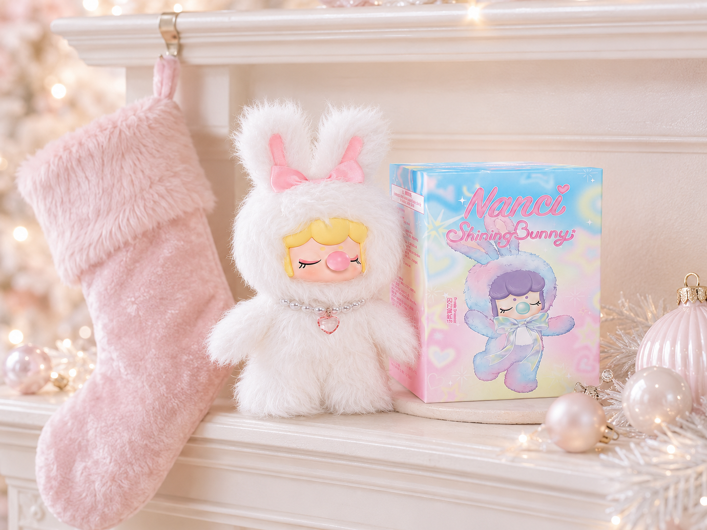 Nanci Shining Bunny figure and box beside a blush Christmas stocking