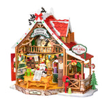 Angled view of Rolife Reindeer Express DS059 DIY miniature house with snowy red roof, Christmas tree and post office counter