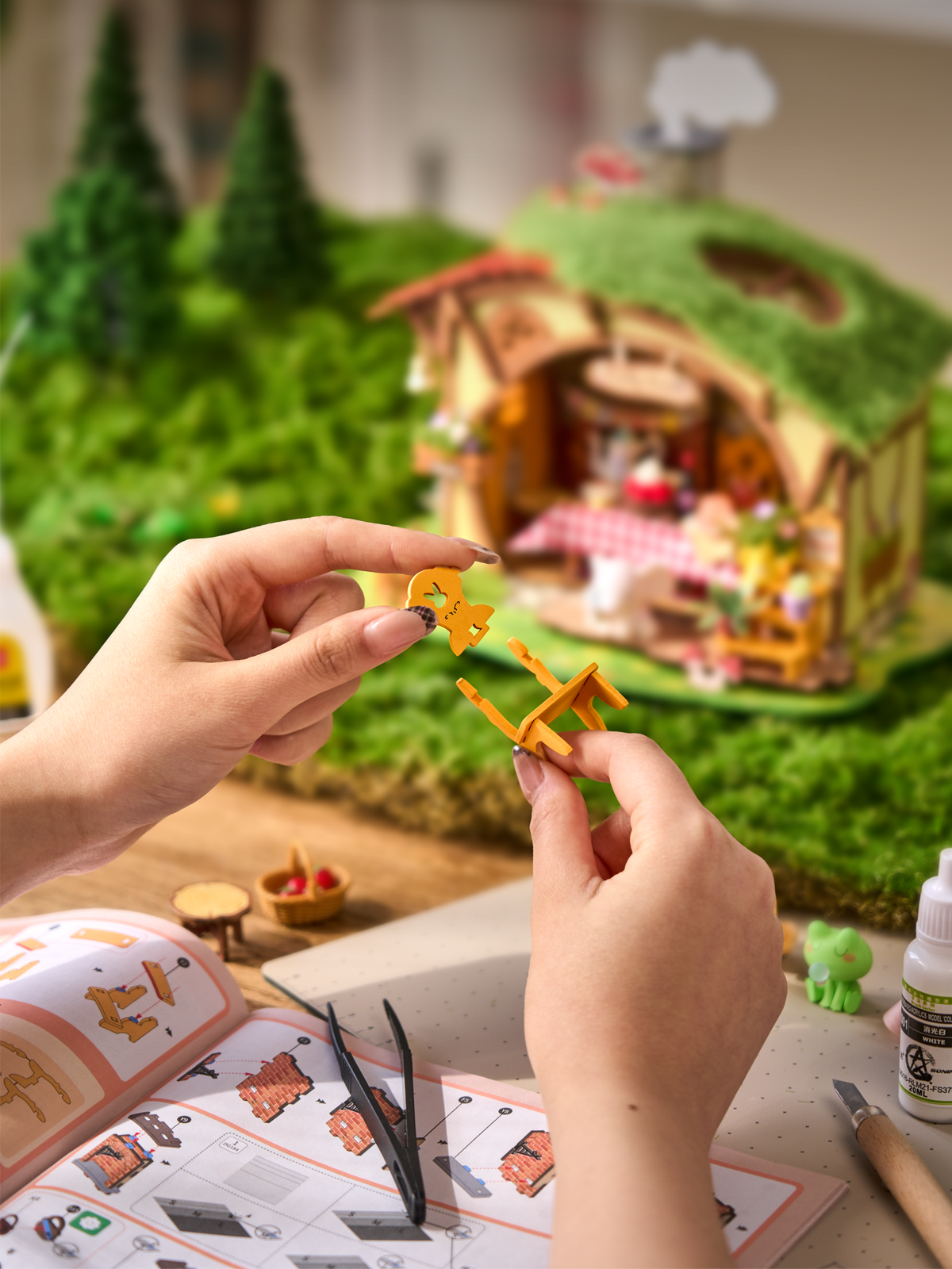 Hands assembling a tiny chair for the Rolife Fluffy Grove DG184 DIY miniature house beside the instruction booklet