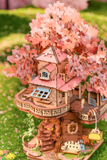 Close-up of Rolife Sakura Tree House TGS04 showing pink blossoms, balcony, stairs and small treehouse windows