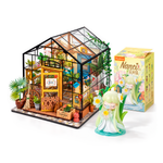 Flower Stories Greenhouse bundle: assembled Cathy Flower House with one example unboxed Nanci Flower Stories figure and its box on white. Figure design varies.