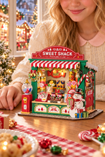 Girl beside the assembled Rolife Christmas Candy Stand DS043 miniature sweet shop on a festive holiday table.