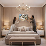 Man and woman in a bedroom with a large bed and chandelier.