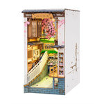 Rolife Sakura Densya TGB01 DIY book nook at an angle, showing a miniature Japanese street, green train and cherry blossoms