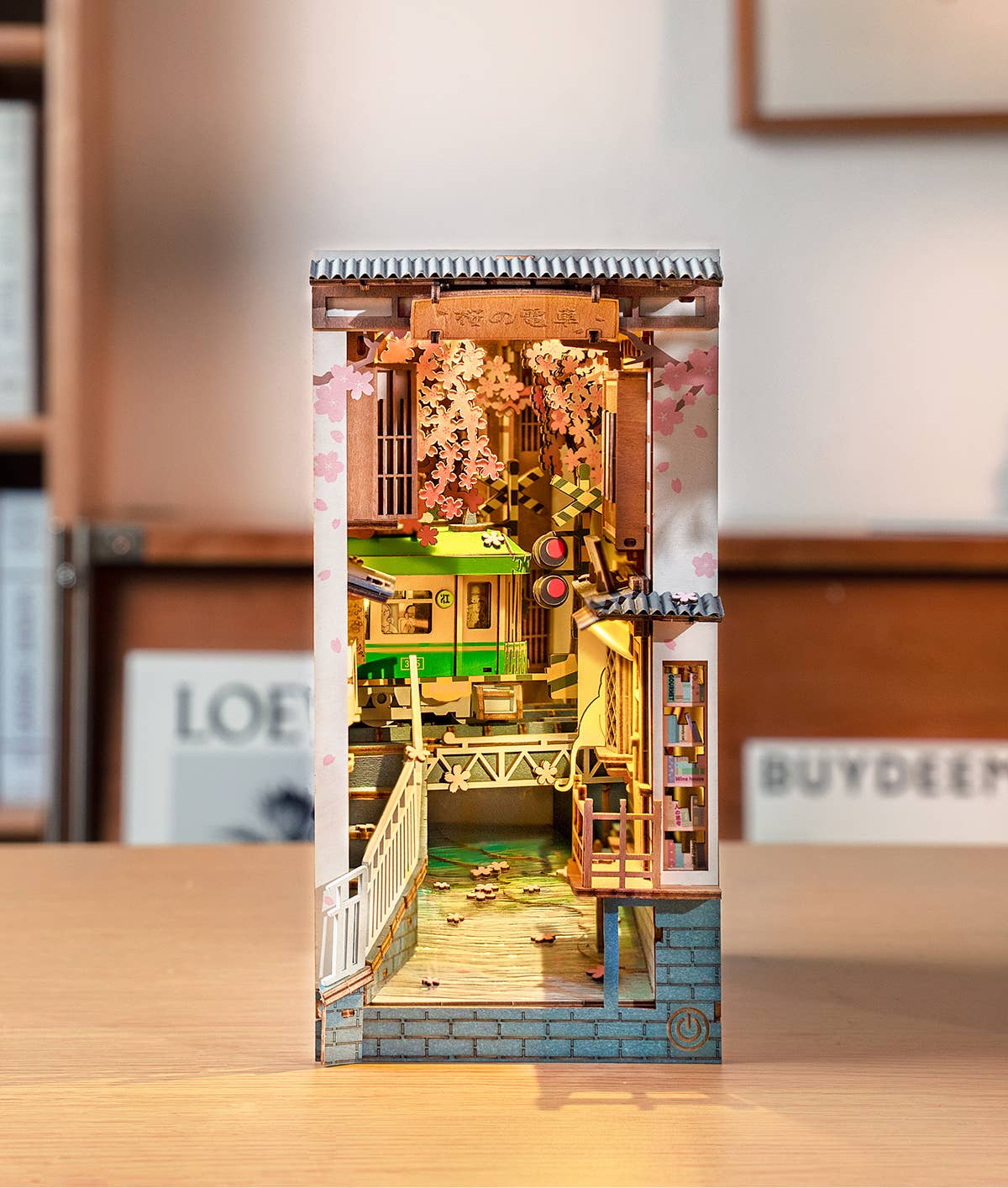Rolife Sakura Densya TGB01 illuminated DIY book nook displayed on a wooden table